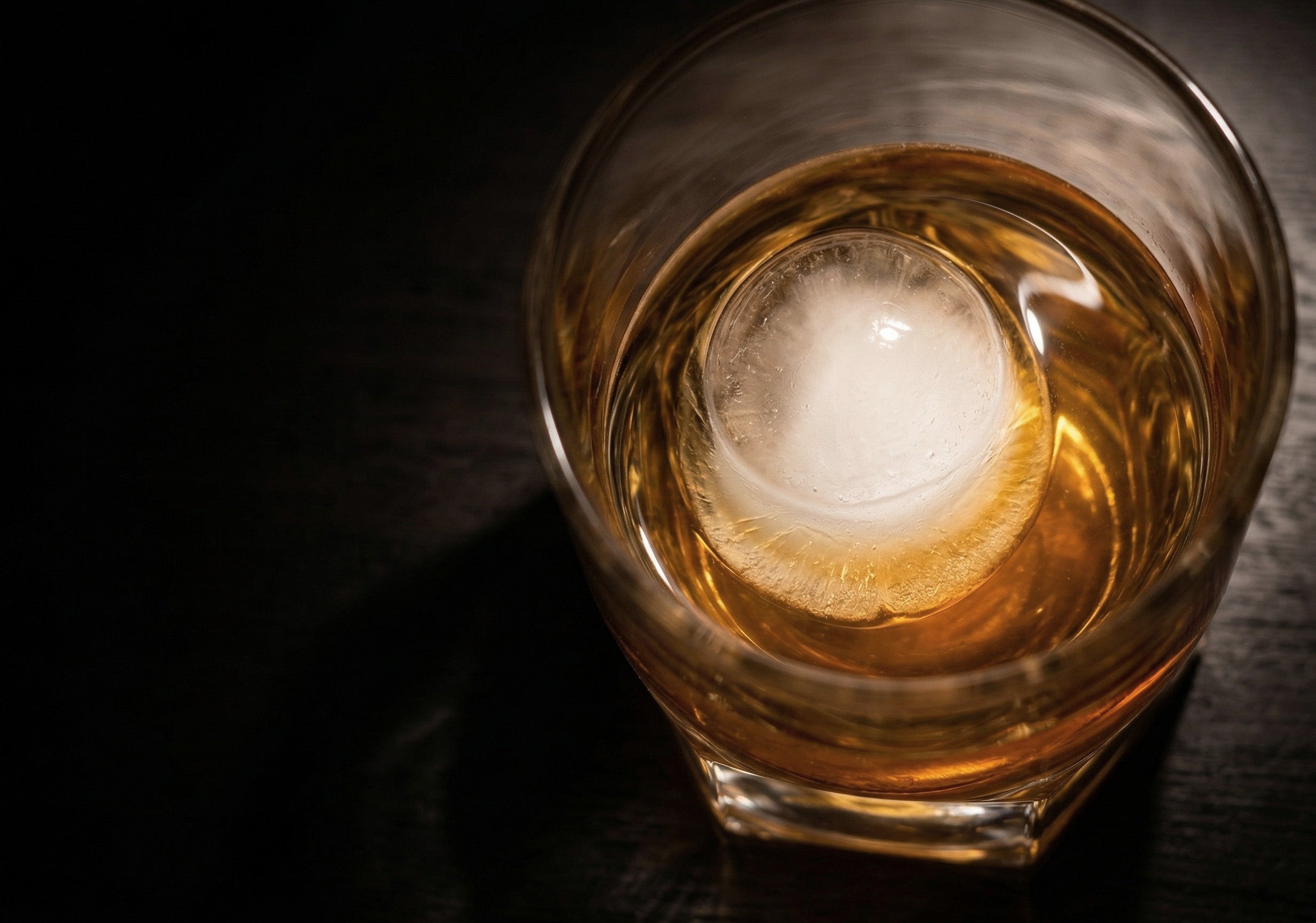 稲花 Pegasus2001 Red Label 透明感のある黄金色の熟成酒と丸氷のロックグラスを上から覗き込んだ写真